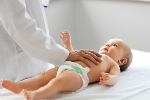 پزشک در حال معاینه نوزاد 