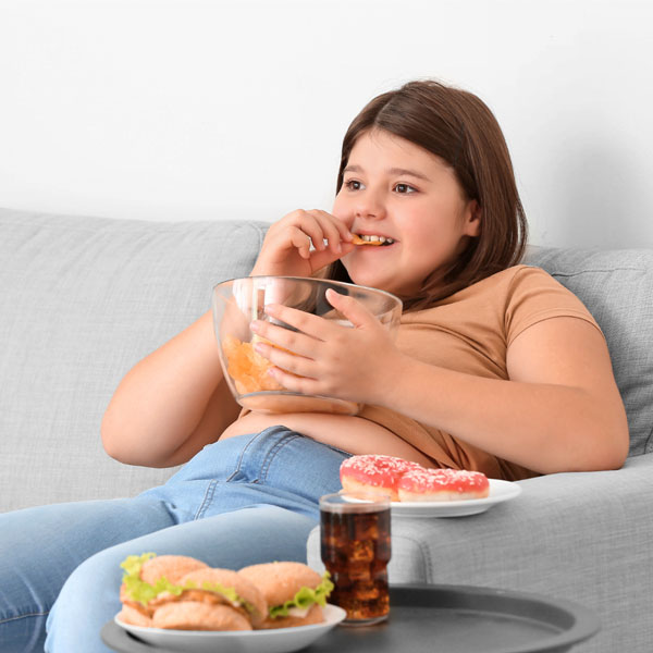 کودک چاق در حال خوردن فست فود