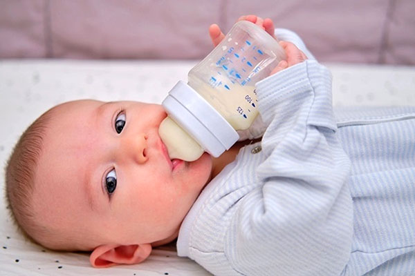 نوزاد در حال خوردن شیر خشک با شیشه 